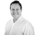 Portrait of James Montgomery, Chief Product Officer of Manufacturo, wearing a white collared shirt and smiling.