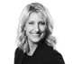 Black and white studio portrait of Becky Kelderman, Director of Sales, smiling and looking at the camera. She has blonde wavy hair and wears a dark blazer.